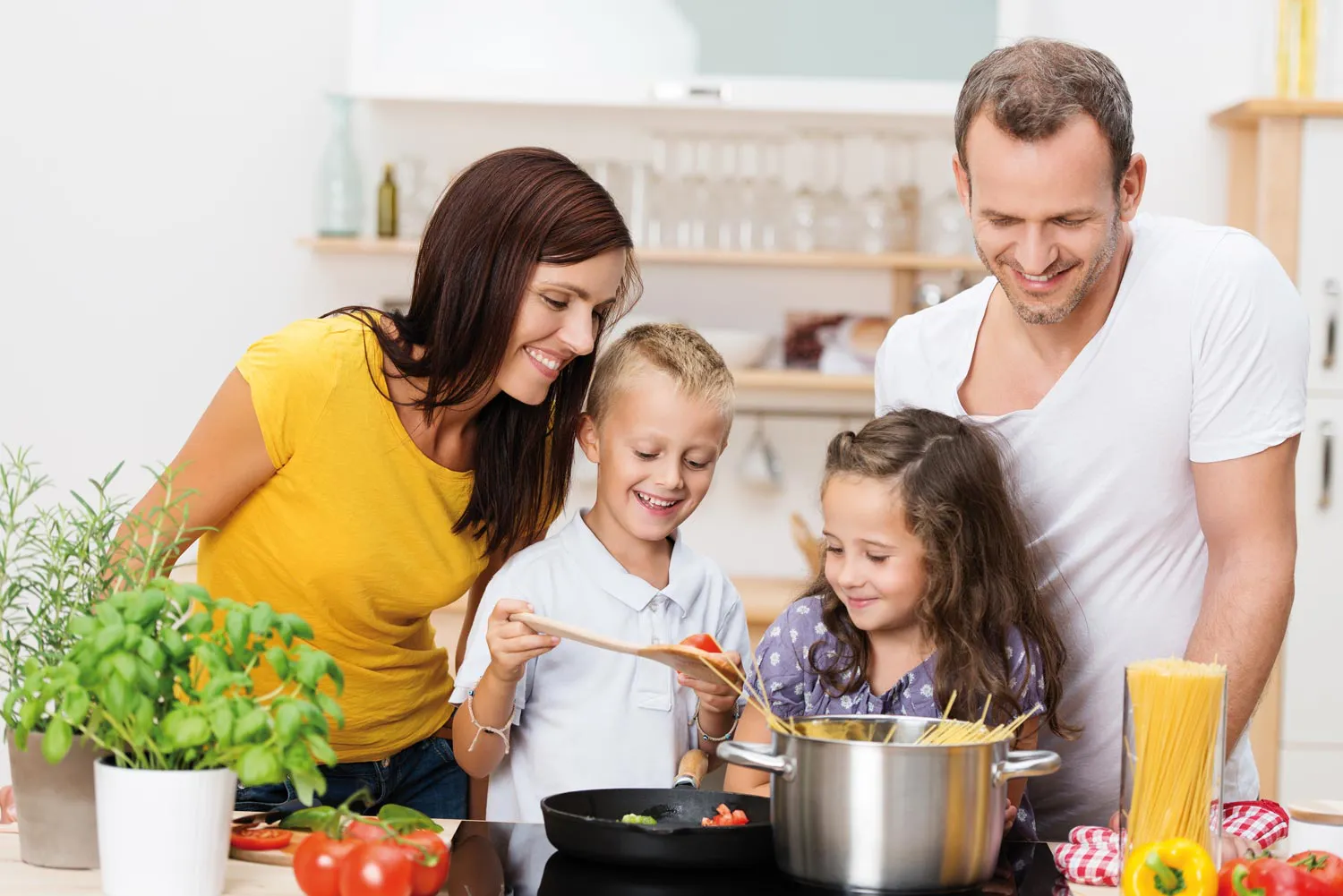 Familie kocht zusammen Spaghetti